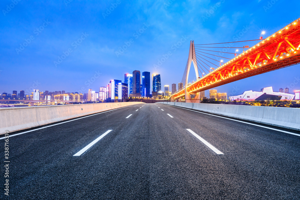 Empty asphalt road and city skyline with buildings at night in Chongqing,China. Empty asphalt road and city skyline with buildings at night in Chongqing,China.