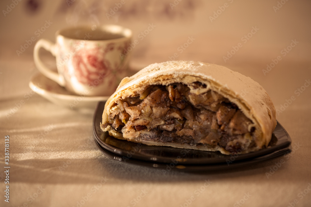 close up of an Apple strudel with hot tea under the Morning light. close up of an Apple strudel with hot tea under the Morning light.
