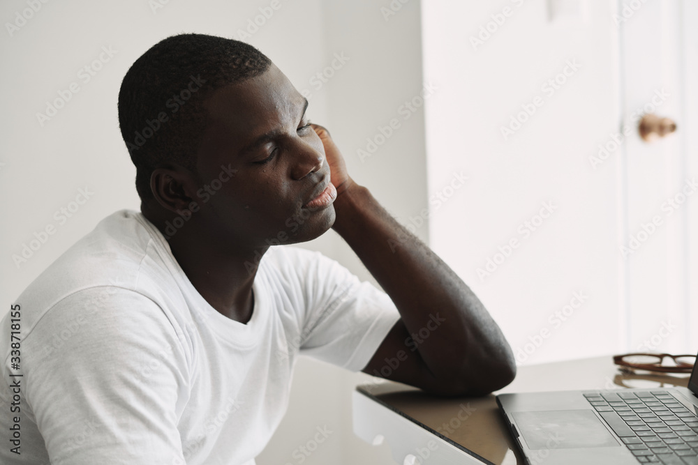 man of african appearance at home in front of a laptop man of african appearance at home in front of a laptop