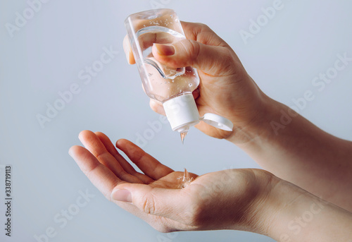Fotografi Close up view of woman person using small portable antibacterial hand sanitizer on hands