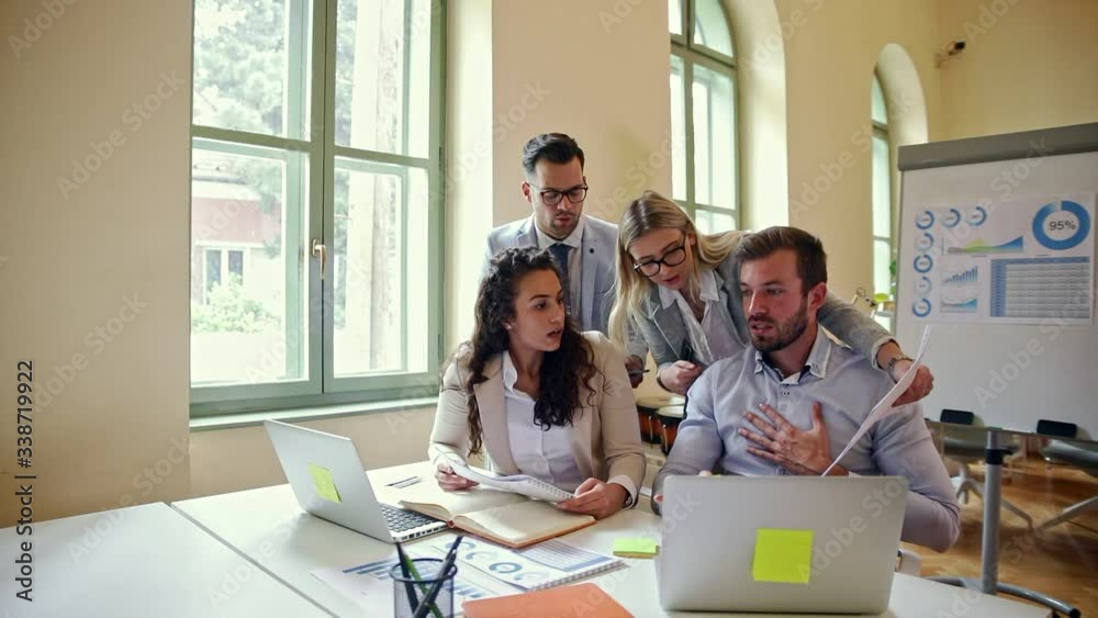 Group of business people working together while sitting at the office desk looking at laptop and discussing about new project. Group of business people working together while sitting at the office desk looking at laptop and discussing about new project.