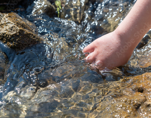 Kind hält Hand in das Wasser