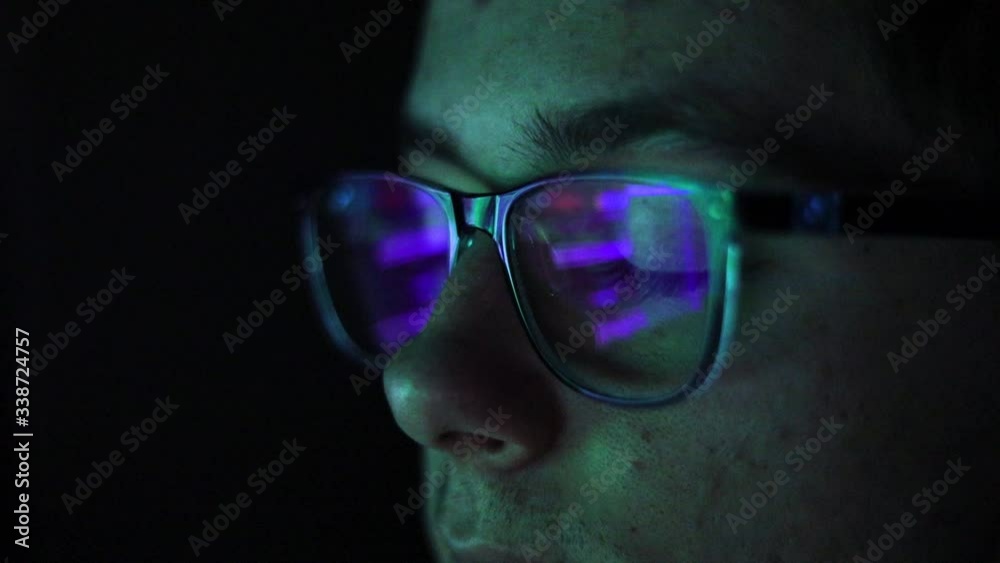 Young male with glasses programming with the computer late at nigh Young male with glasses programming with the computer late at nigh