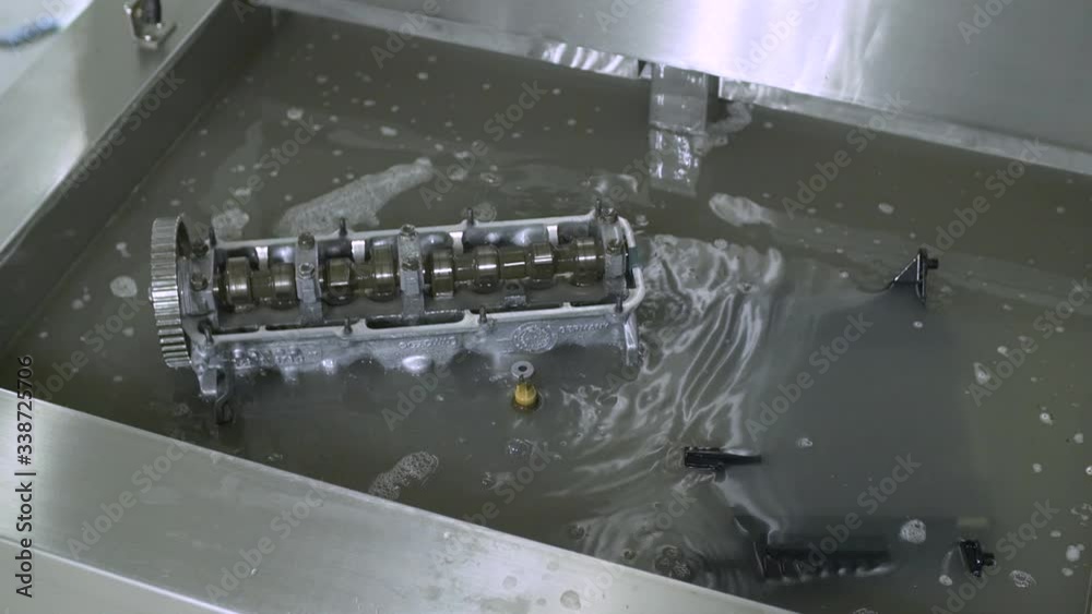 Rinsing engine and filter parts in water using ultrasonic waves.