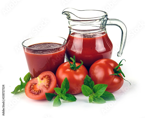 Fresh red tomatoes in basket and tomato juice in glass and jug on white