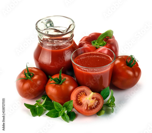 Jug, glass of tomato juice and fruits with green leaves isolated on white