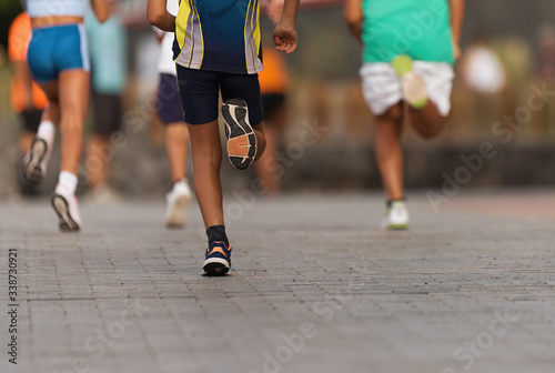 Running children, young athletes run in a kids run race,running on city road detail on legs