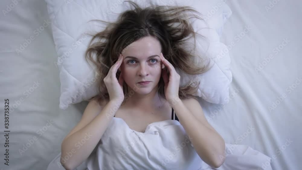 Top view of young woman looking at camera while suffering from headache. Top view Top view of young woman looking at camera while suffering from headache. Top view