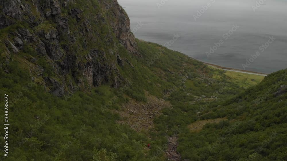4K aerial drone reveal motion of mountain climbers climbing down a valley from the majestic Dønnamannen in Northern Norway 4K aerial drone reveal motion of mountain climbers climbing down a valley from the majestic Dønnamannen in Northern Norway