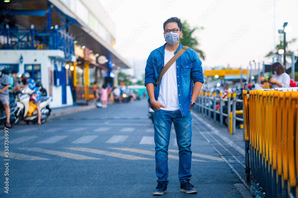 Portrait Of Young man With Mask outside the supermarket. Concept, diseases, viruses, allergies, air pollution. The image face of a young man wearing a mask to prevent germs, toxic fumes, and dust. 