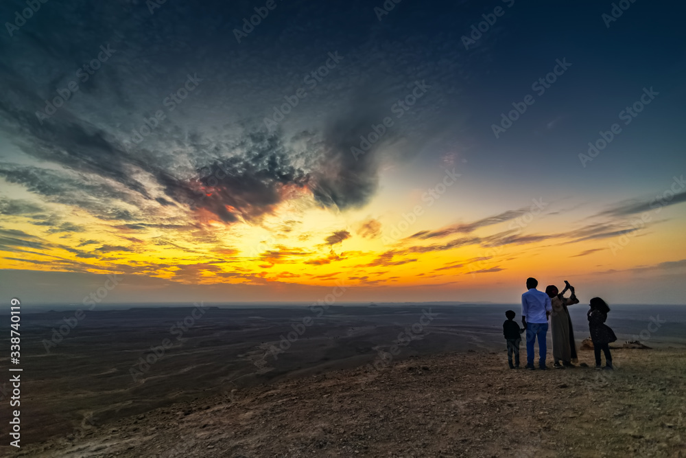 Tourist family on Edge of the World, a natural landmark and popular tourist destination near Riyadh -Saudi Arabia 26-Dec-2019 (Selective focus on the subject and background blurred).