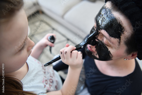 mother and daughter at home making facial mask beauty treatment