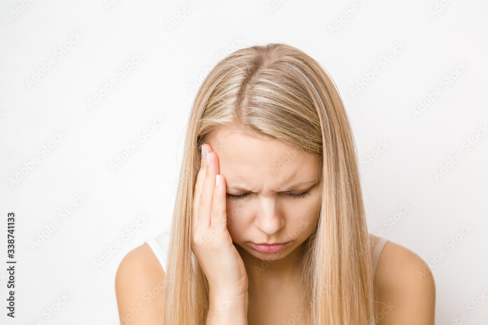 Young, adult blonde lady trying to calm down. Lonely, nervous woman touching head. Memory disorder. Suffering from psychological problems. Women's issues. Face close up on light gray background. Young, adult blonde lady trying to calm down. Lonely, nervous woman touching head. Memory disorder. Suffering from psychological problems. Women's issues. Face close up on light gray background.