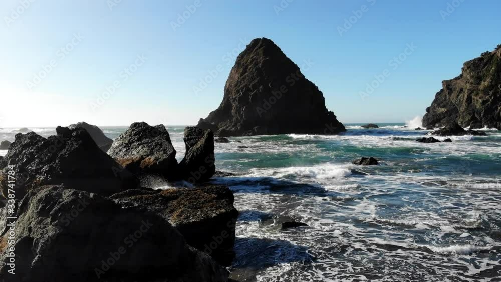 Aerial view of seashore with tide, birds eye of waves meet with coastline and rocky cliff in Pacific Ocean, summer breeze and scenic landscape at island
