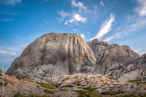 Landscape view of the mountain and blue sky in the background. Conglomerate of white limestone cliffs looking like crown. Tulo's Rafters, Velebit Nature Park, Croatia.