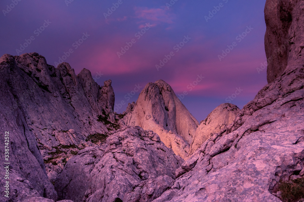 Landscape view of the mountain and purple sky in the background. Conglomerate of white limestone cliffs looking like crown. Tulo's Rafters, Velebit Nature Park, Croatia.