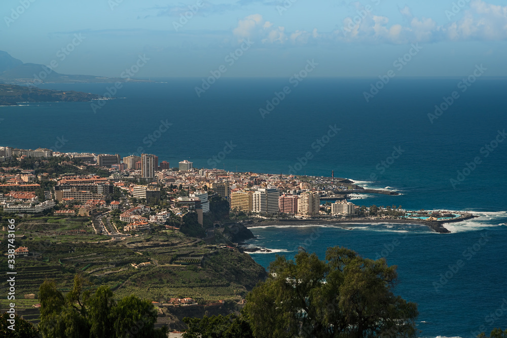 Aerial view of Puerto de la Cruz - Tourist city in Tenerife, Canary islands, Spain. The Atlantic ocean, the coast and mountains in the background. 