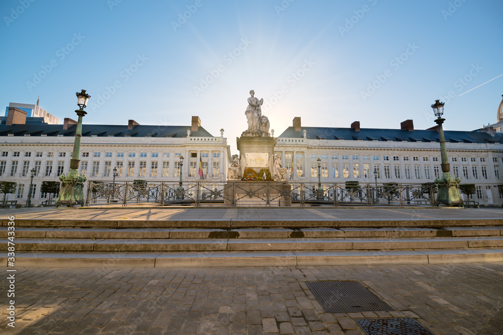 Martyrs' Square (Place des Martyrs). Sunrise behind statue. Belgian flag. Brussels, Belgium