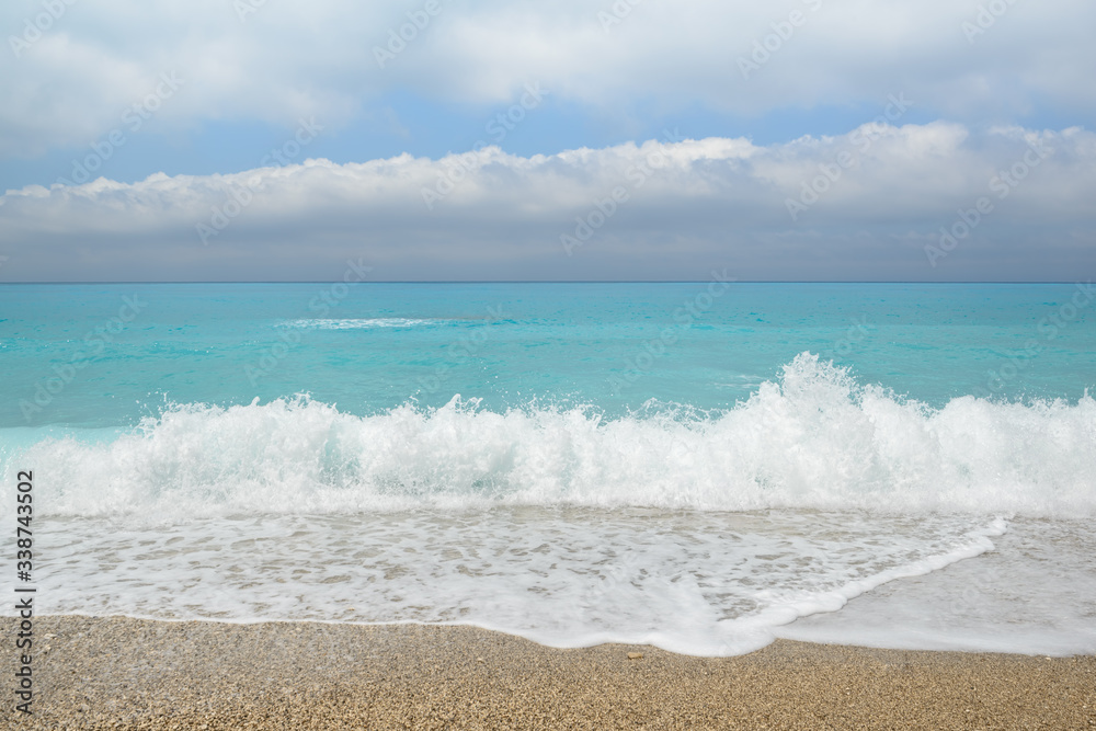 Beautiful blue sea with fluffy clouds and beach seascape. Gialos beach, Lefkada island, Greece.