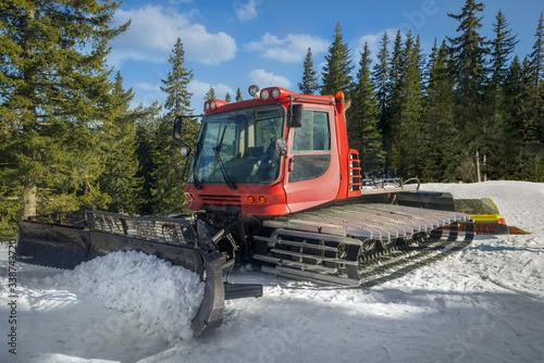 Snow-grooming machine. Snow cat machine making the ski run smooth. Snowcat ready to grooming for skiing and snowboarding on the mountain.