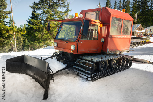 Snow-grooming machine. Snow cat machine making the ski run smooth. Snowcat ready to grooming for skiing and snowboarding on the mountain.