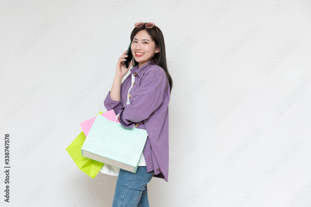 A young asian woman with a shopping bag in her hand A young asian woman with a shopping bag in her hand