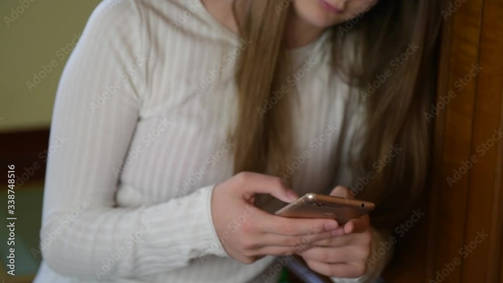 Young girl millenial using smartphone, close up. Young people and college education. Coronavirus. Quarantine.Young people and college education. Female student with mobile telephone at home Young girl millenial using smartphone, close up. Young people and college education. Coronavirus. Quarantine.Young people and college education. Female student with mobile telephone at home