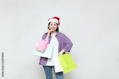 A young asian woman with a shopping bag in her hand