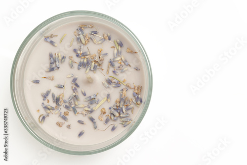 Aromatized candle with little lavanda dry flowers above view isolated on white background