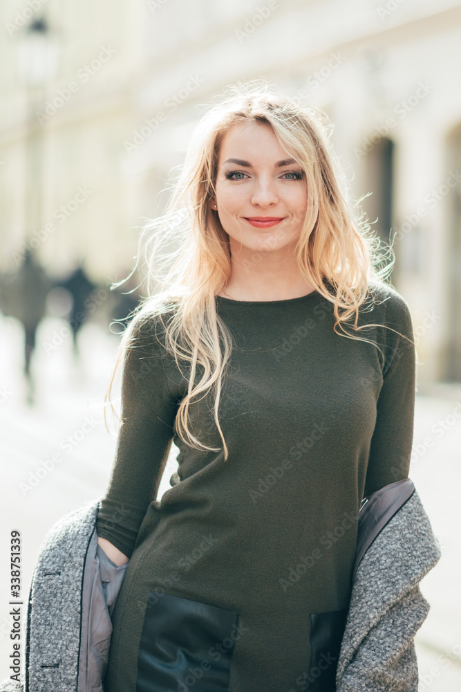 Close up portrait of young blonde beautiful woman which walks in the city