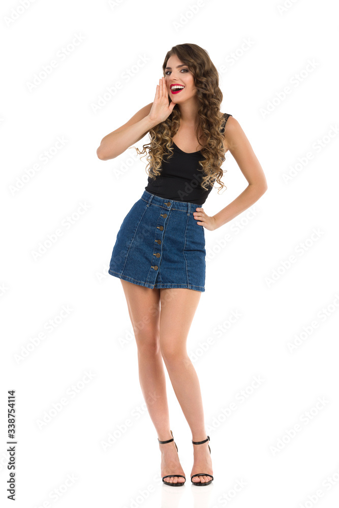 Young Sexy Woman In Jeans Mini Skirt And High Heels Is Holding Hand On Chin And Talking Young Sexy Woman In Jeans Mini Skirt And High Heels Is Holding Hand On Chin And Talking