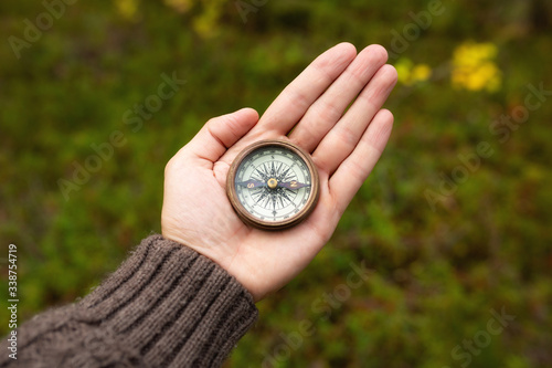 Male hand holding vintage old compass. Travel concept. 