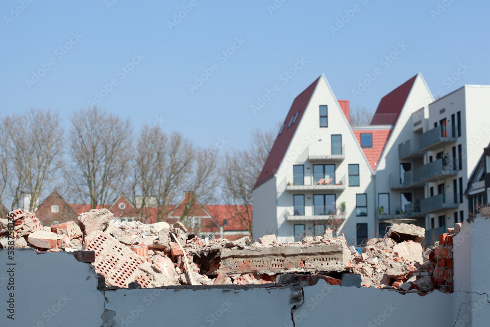 Trümmer von einem  Abbruchhaus, im Hintergrund moderne Wohngebäude