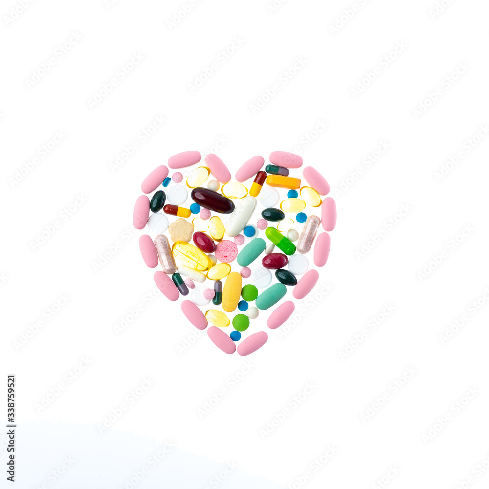 Pink pills in the shape of a heart on a white isolated background. One-to-one square shot for social networks. Heart shape made of tablets for therapy, concept of treatment and health care. Pink pills in the shape of a heart on a white isolated background. One-to-one square shot for social networks. Heart shape made of tablets for therapy, concept of treatment and health care.