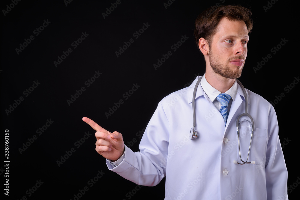 Portrait of bearded man doctor pointing finger and looking away Portrait of bearded man doctor pointing finger and looking away