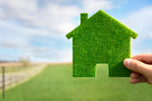Fotografija Green ecological house in empty field