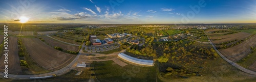 360° Panoramic drone picture of the city Moerfelden-Walldorf with the skyline of Frankfurt in the background at evening