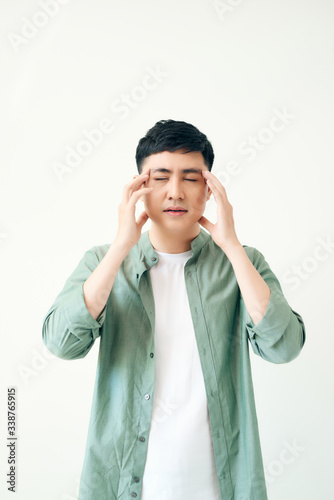 Asian man getting a headache on white background