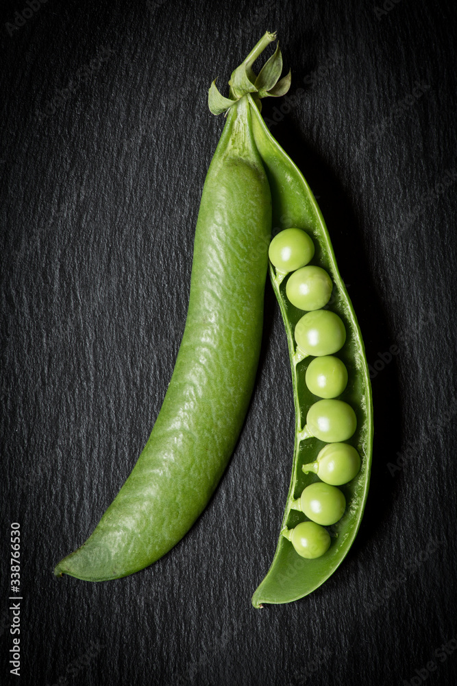 open and isolated pea pod on a black background in zenithal view open and isolated pea pod on a black background in zenithal view
