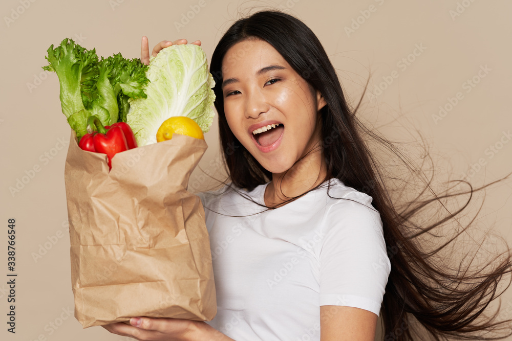 young woman holding a bag full of groceries young woman holding a bag full of groceries