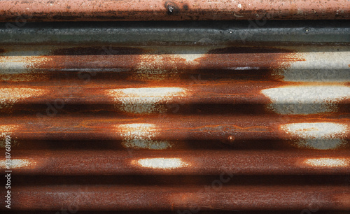 An old corrugated tin sheet showing curved rusty texture and background.  Building, construction, corrosive  material and renovation categories.