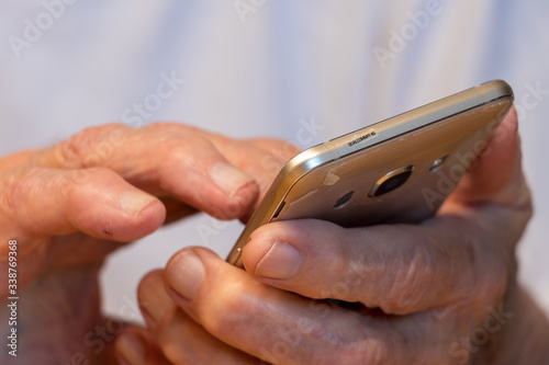 Senior tippt auf Smartphone