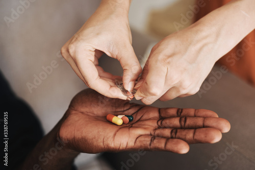 hands of a man holding a handful of pills