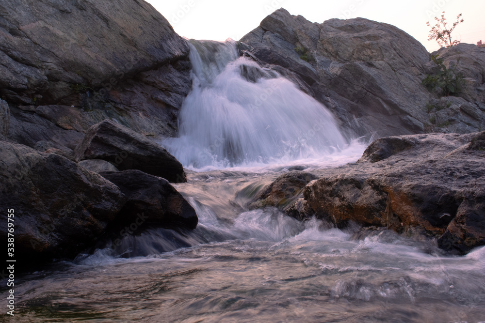 a small waterfall coming down the hill cutting the rocks a small waterfall coming down the hill cutting the rocks