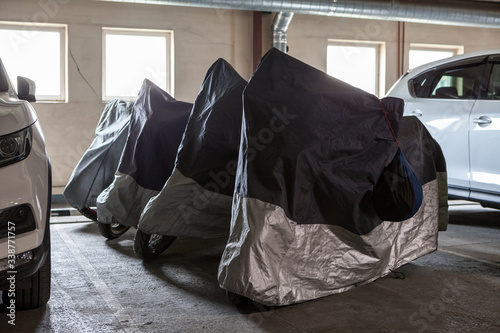 Four motorcycles are parked in an indoor underground parking facility during winter season, temporary closing-down