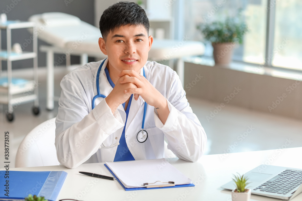 Naklejka premium Male Asian doctor working in clinic