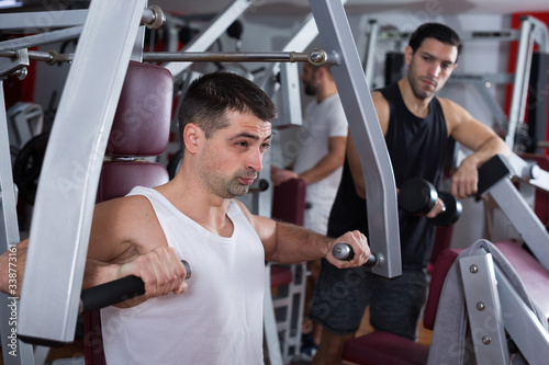 Man on power exercise machine in gym