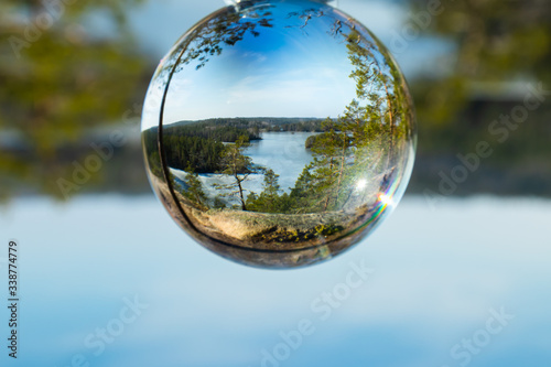 Beautiful landscape in glass ball with icy lake in the national park Repovesi, Finland © Elena Noeva