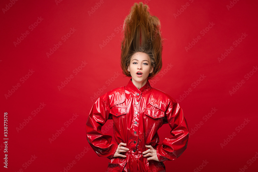 Portrait of handsome caucasian female with long fair hair on top in red leather costume hanging Portrait of handsome caucasian female with long fair hair on top in red leather costume hanging