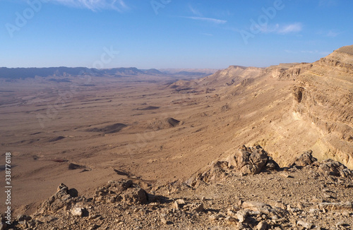 The desert landscape with the big valley, the sandstone mountains on its edge, the blue sky